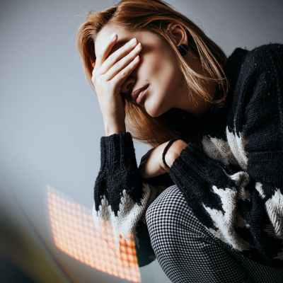 distressed upset woman covering eyes with hand