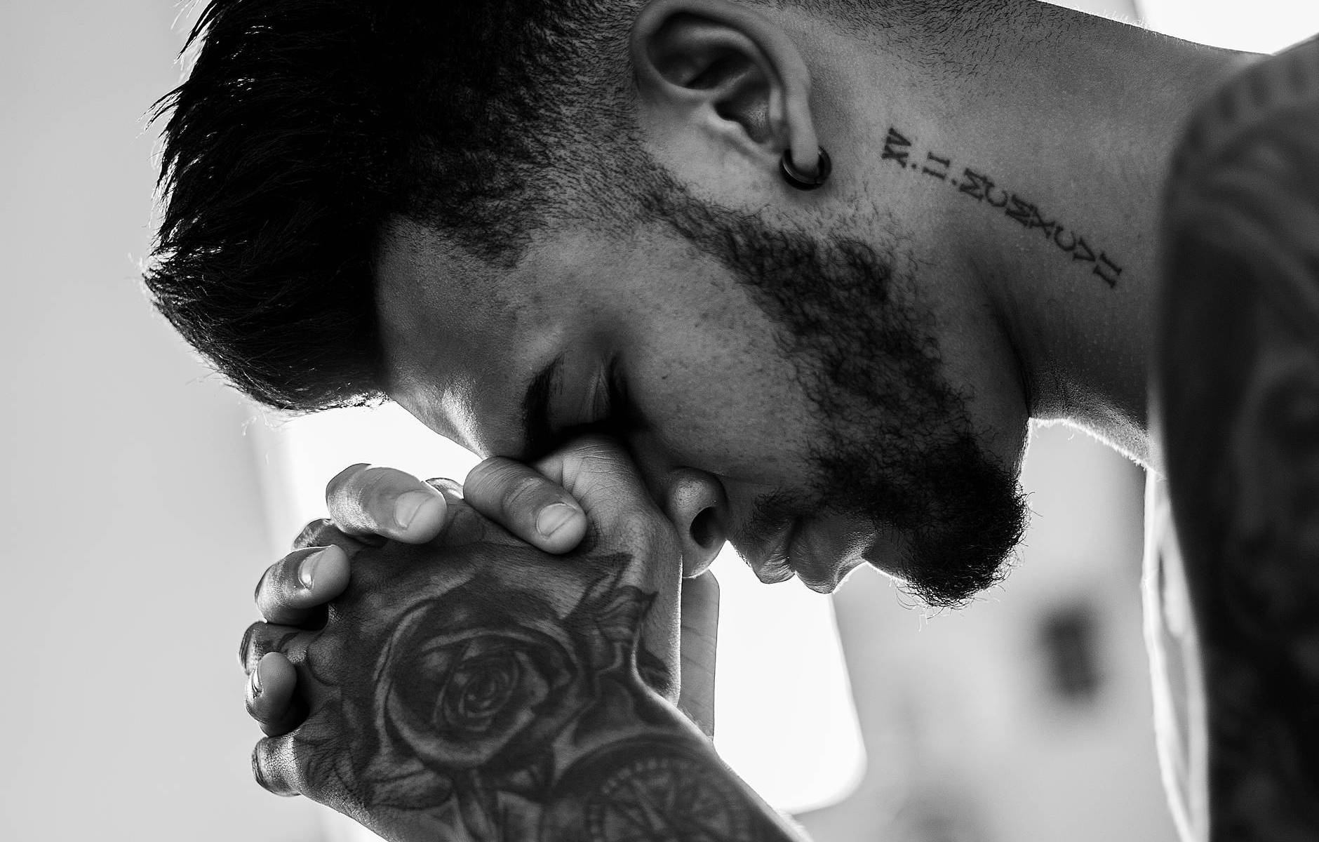 man tattooed praying