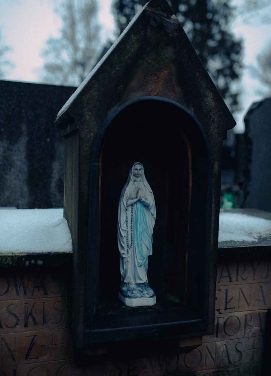 virgin mary statue on black wooden window