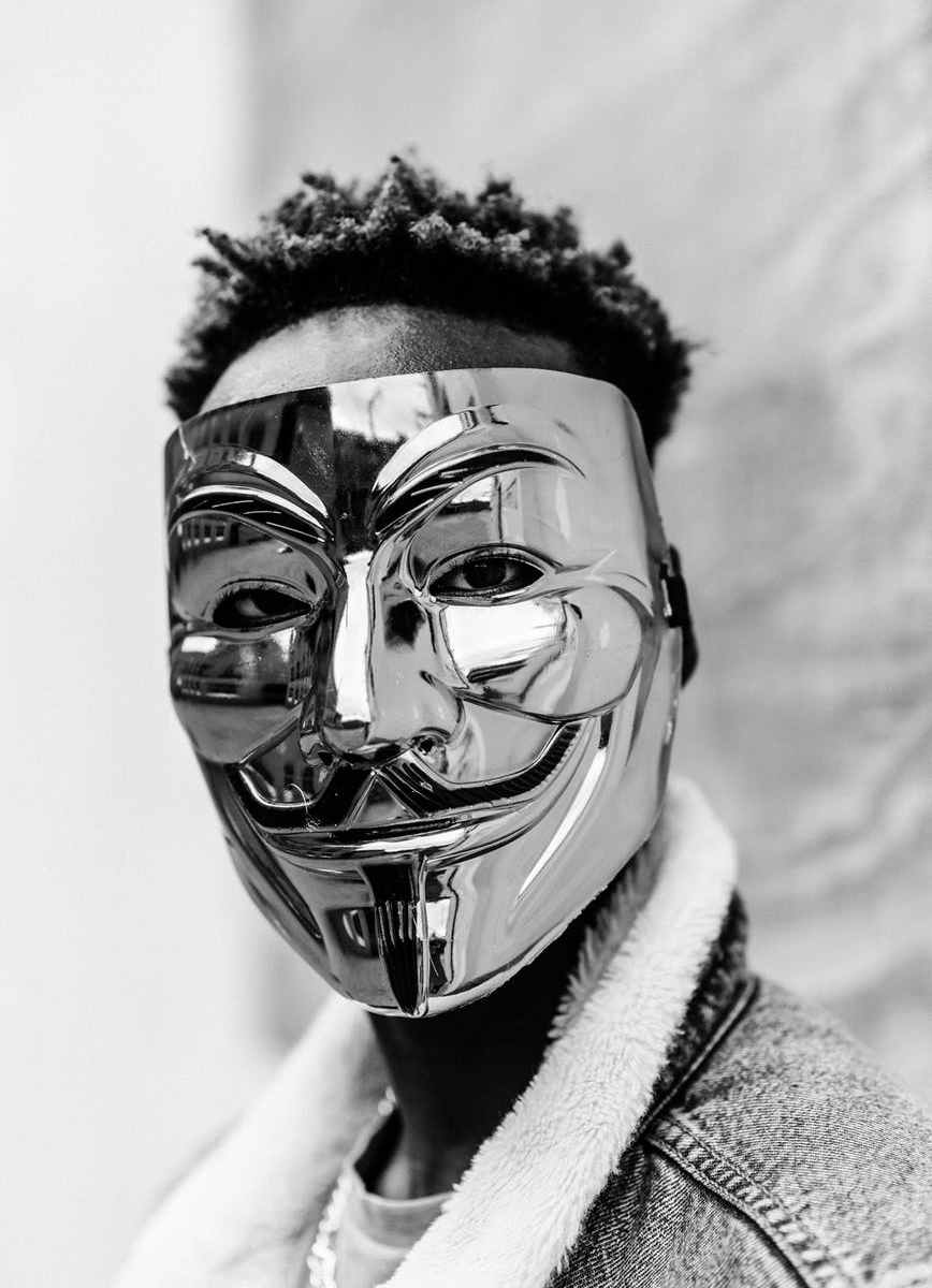 black activist in anonymous mask looking at camera