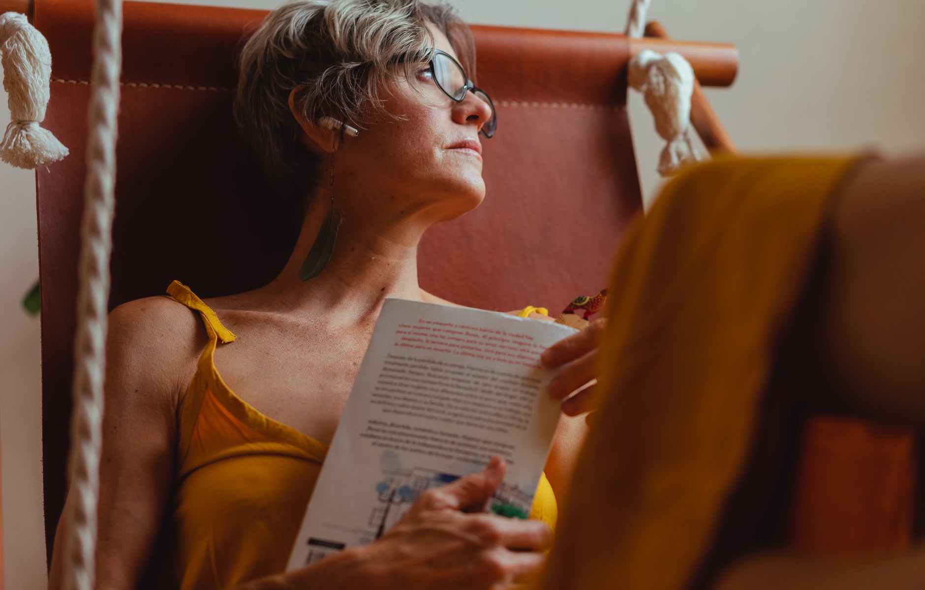 elderly woman looking pensive while holding a book