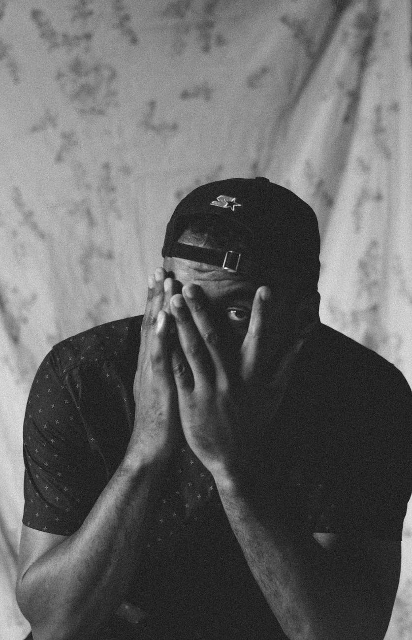 monochrome photo of a man hiding his face